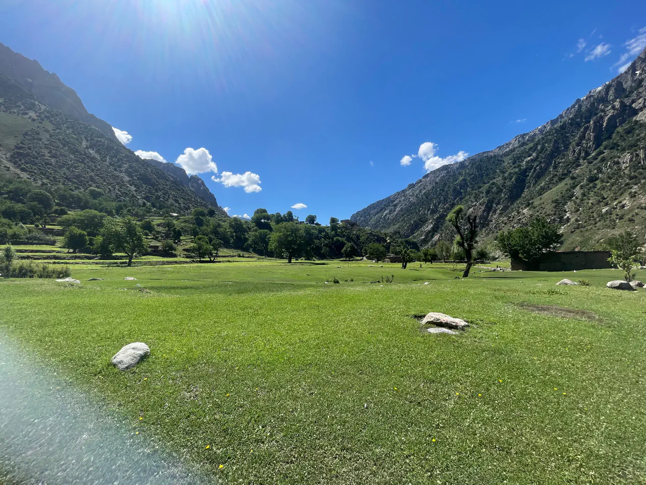 A meadow on the valley floor of Kantiwa with mountains behind