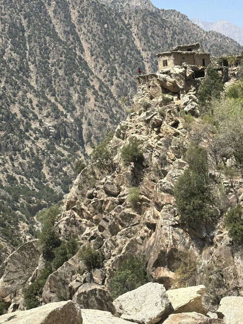 خانهای از سنگ و چوب بر فراز صخرهای در مندول، با دامنهٔ تند جنگلی در آن سوی تنگه