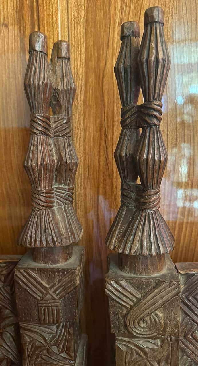 The finials of two Nuristani chairs, carved as fluted bundles bound with rope