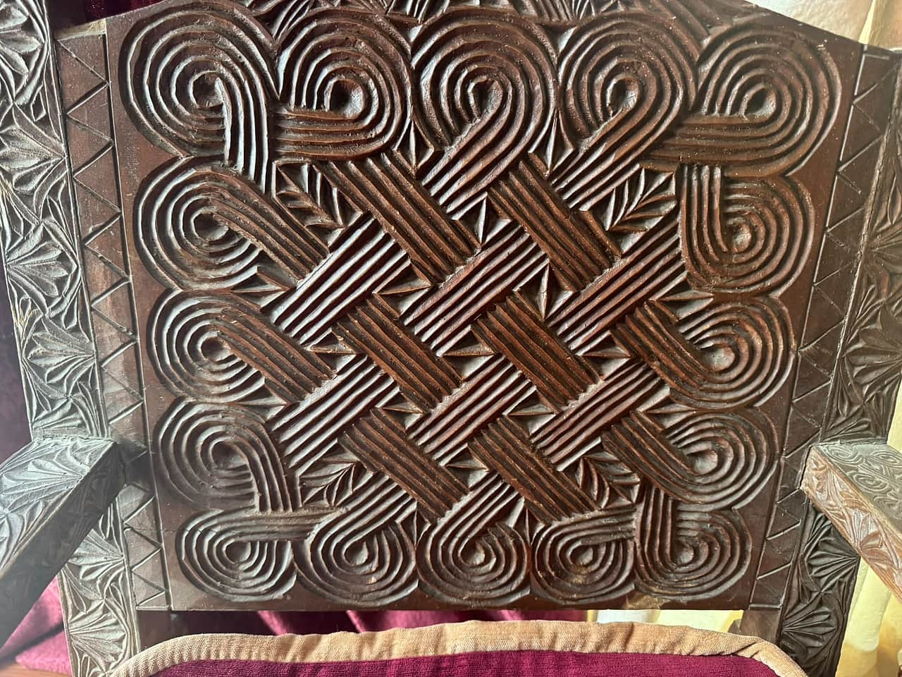 The endless-knot back panel of a carved Nuristani chair