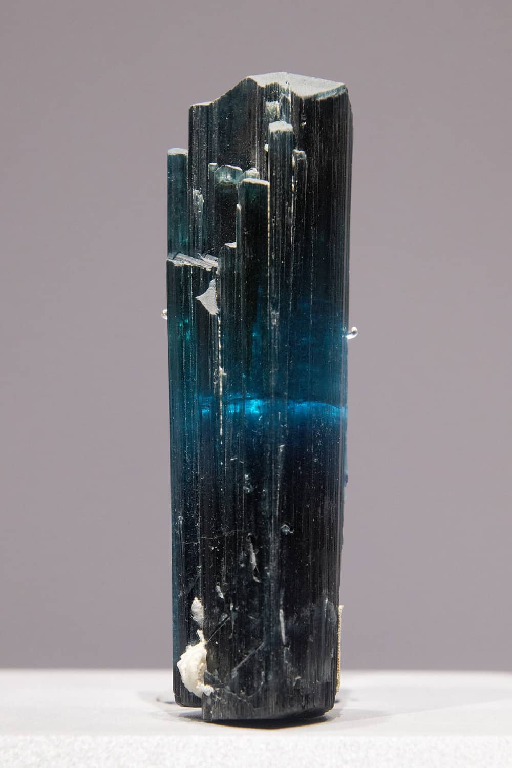 A single dark tourmaline crystal lit from behind to show a band of deep blue, from Paprok in Nuristan