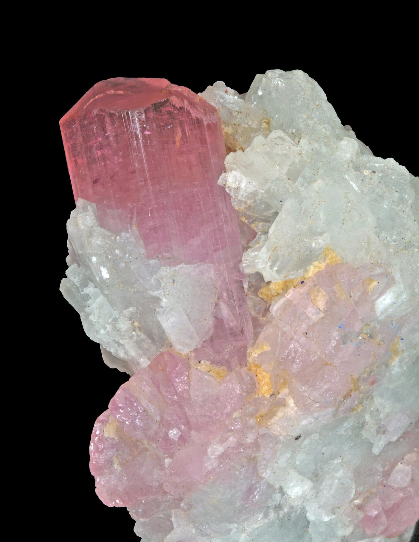 A pink tourmaline crystal standing among quartz and feldspar from the Paprok mine in Nuristan