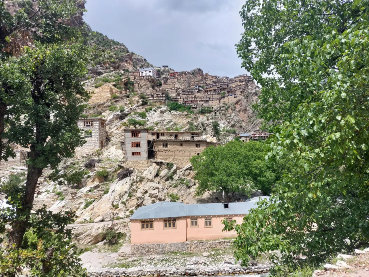 A tiered village of timber and stone houses on a rocky hillside in the Waygal valley